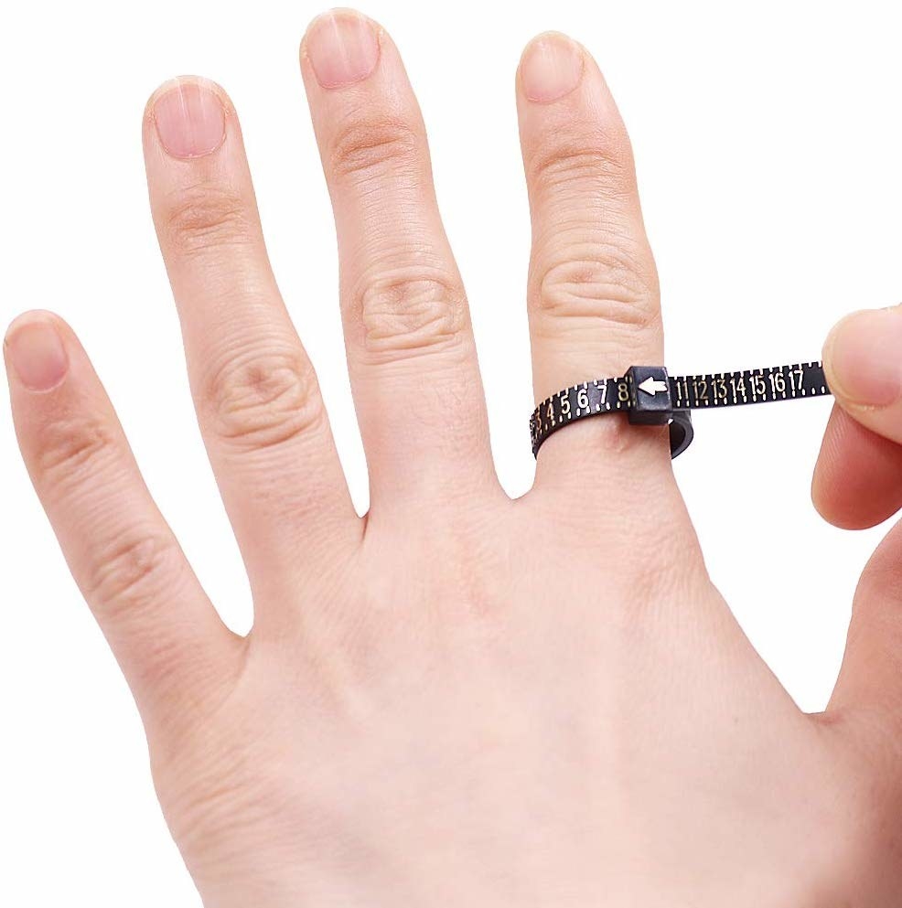 A ring size measurer being used on a person's finger.