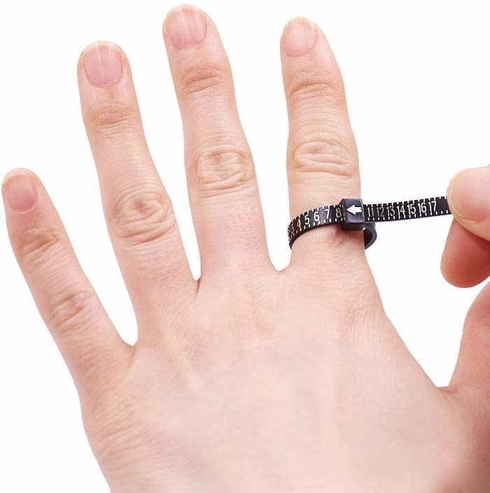 A ring size measurer being used on a person&#x27;s finger.