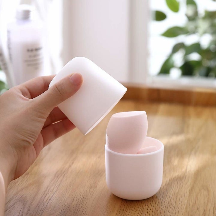 someone taking the top off the silicone sponge holder