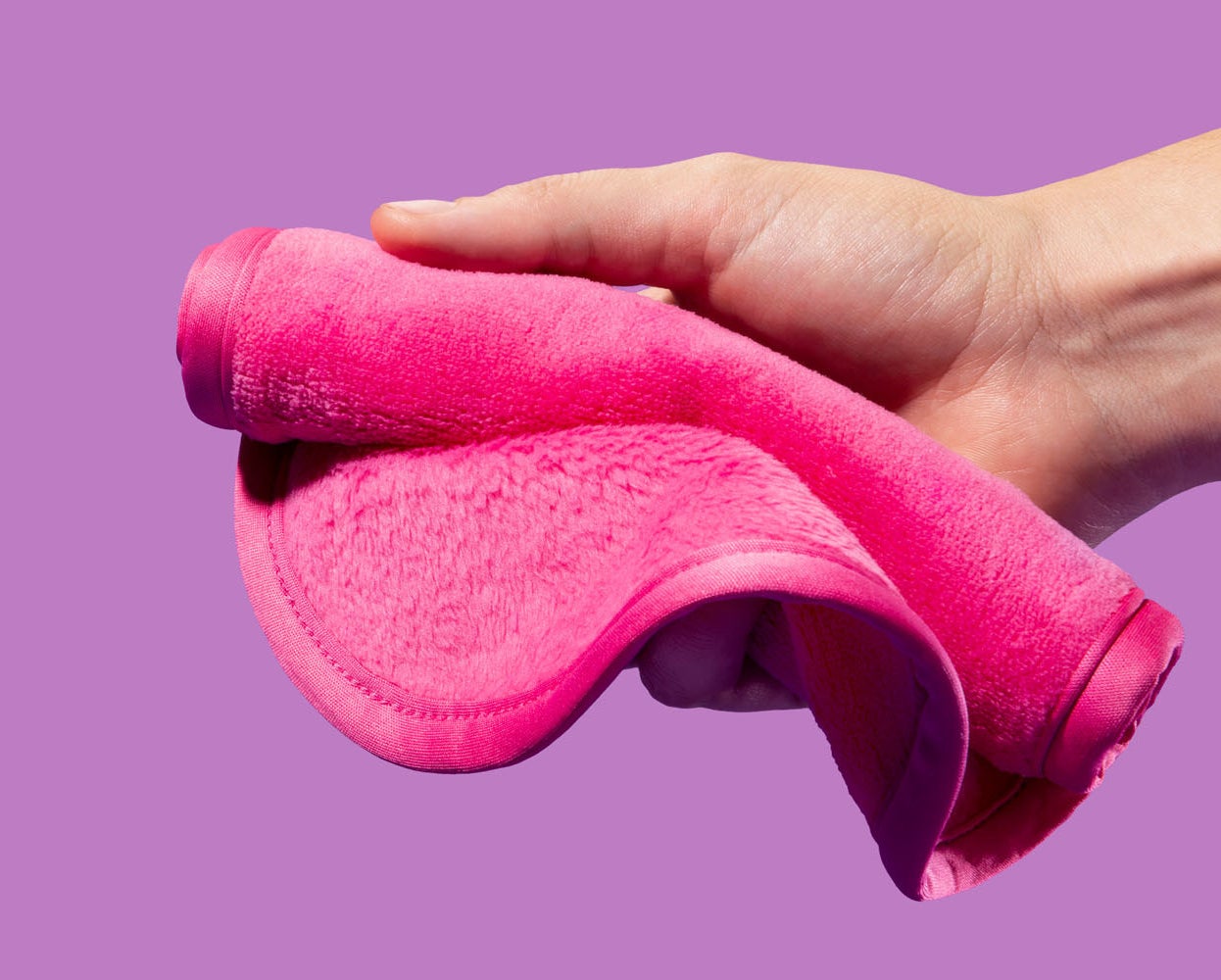 a hand holding the pink makeup erasing cloth