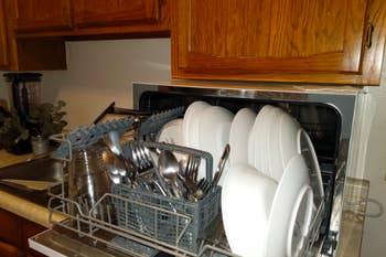 the dishwasher open holding lots of dishes