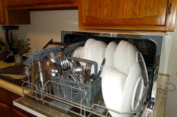 the dishwasher open holding lots of dishes