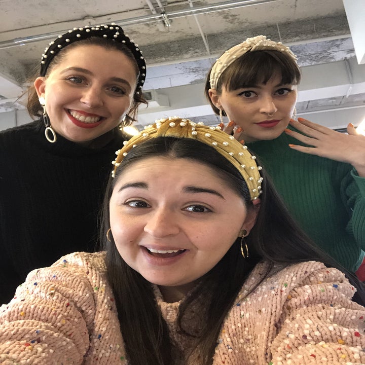 three buzzfeed employees wearing velvet headbands with pearls on them