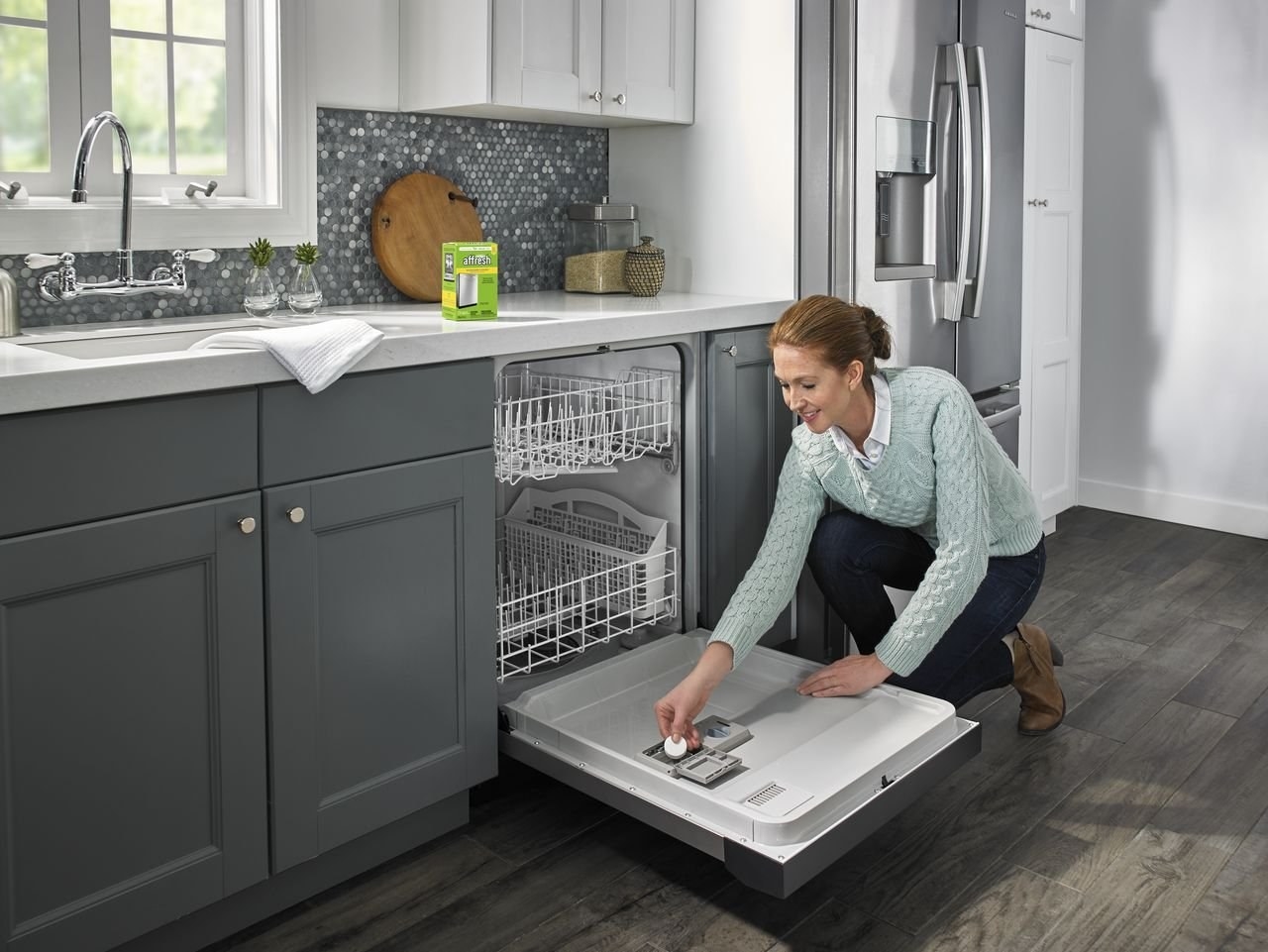 a model putting a cleaning tablet in a dishwasher