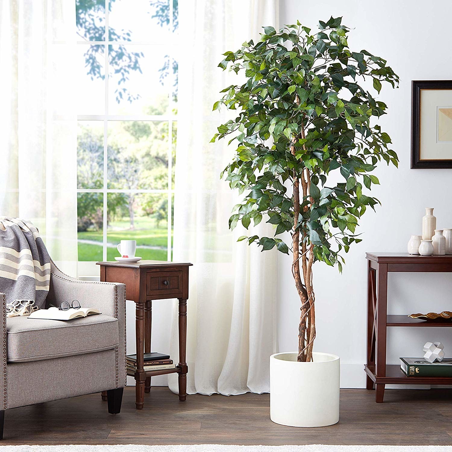 The tree in a white planter inside of a home