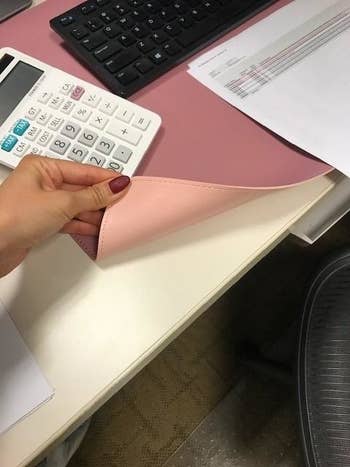 A pink desk mat showing the light pink on the reverse side 