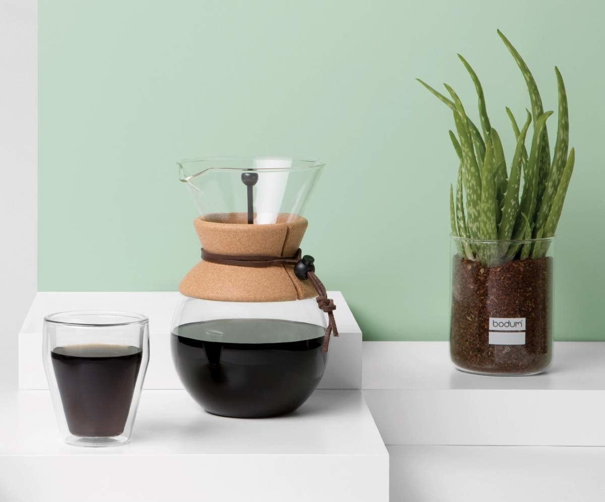 A transparent glass pour over coffee maker with cork accents 