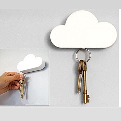 Keys being hung on the cloud-shaped key holder that&#x27;s installed on a wall