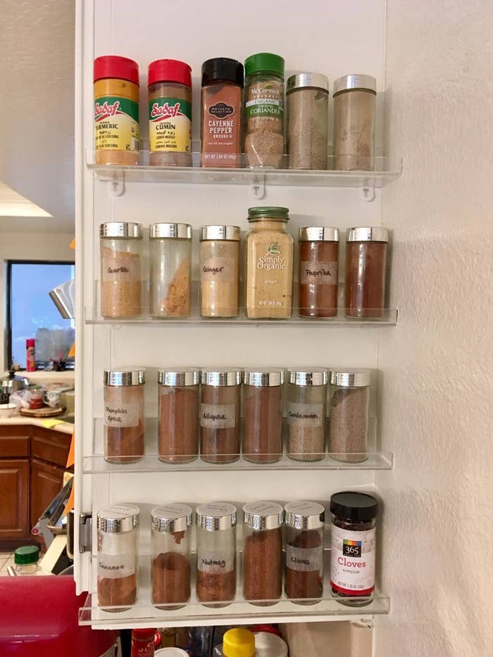 four narrow clear acrylic shelves on side of reviewer&#x27;s kitchen cabinets, each with about six jars of spices each