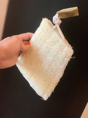 a reviewer photo of the loofah laying flat fresh out of the packaging 