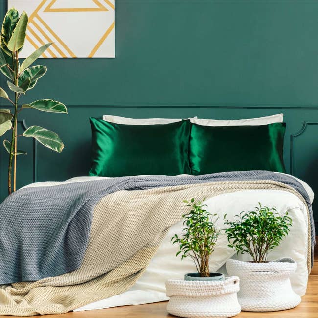 Stock photo of a bed with green satin pillows on them