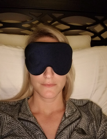 reviewer wears black 3D-contoured sleeping mask