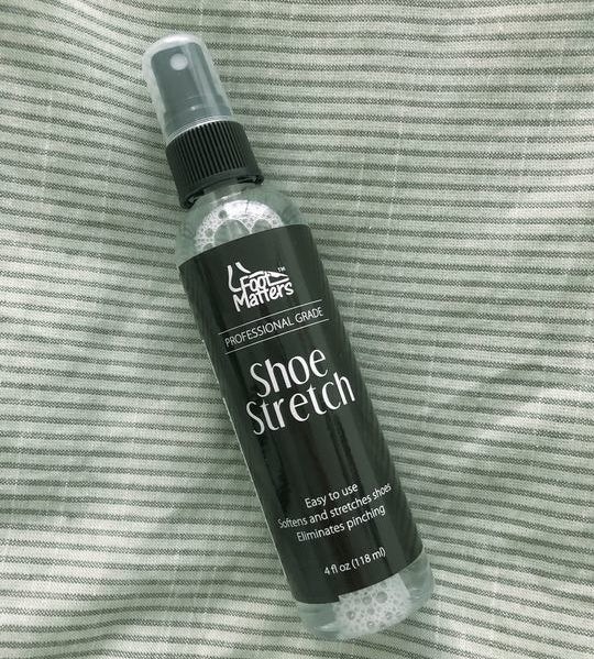 A bottle of boot-stretching spray on a bed