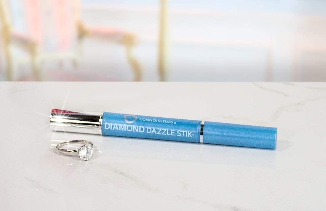 The cleaning pen next to a diamond ring