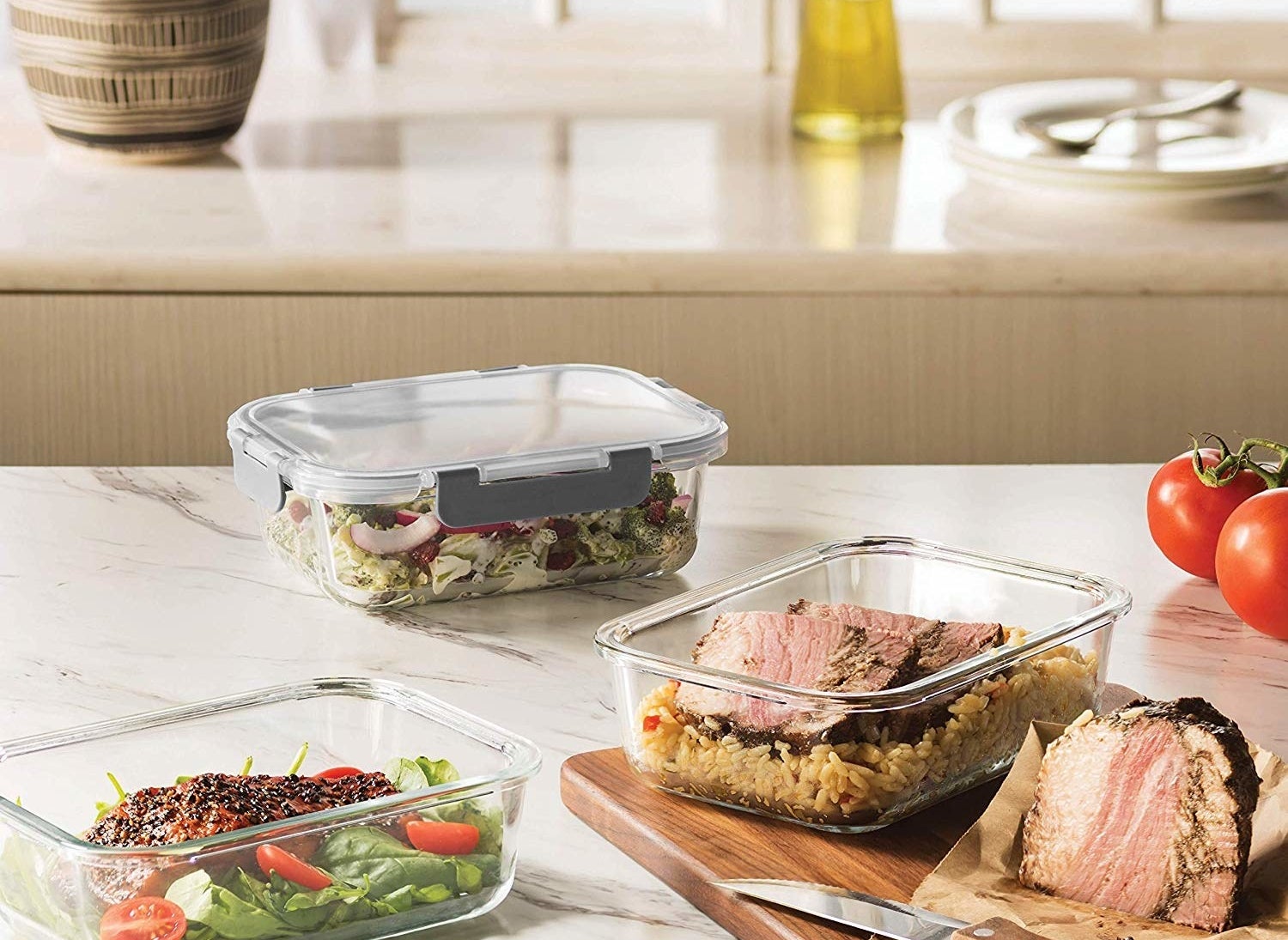 a salad, meat and rice, and salmon inside meal prep containers
