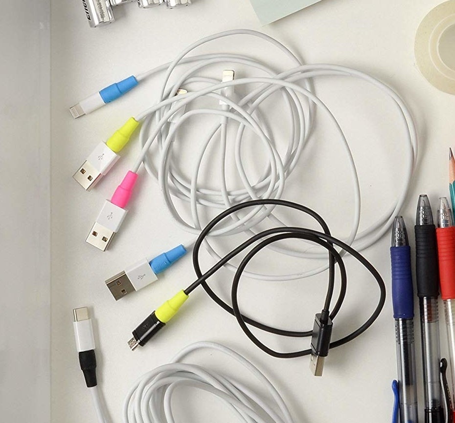 Several USB cords in a drawer with the cable protectors attached to them