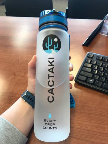 A reviewer holding the water bottle, showing the size