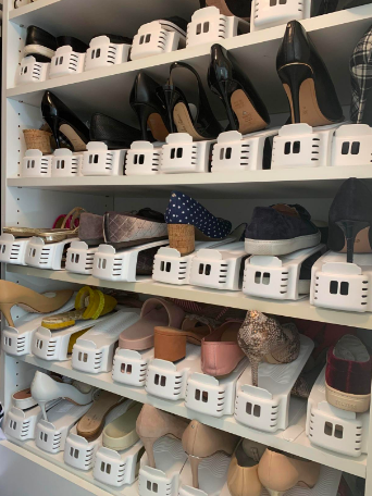 A closet with five shelves filled entirely with pairs of shoes, each organized with these shoe holders 