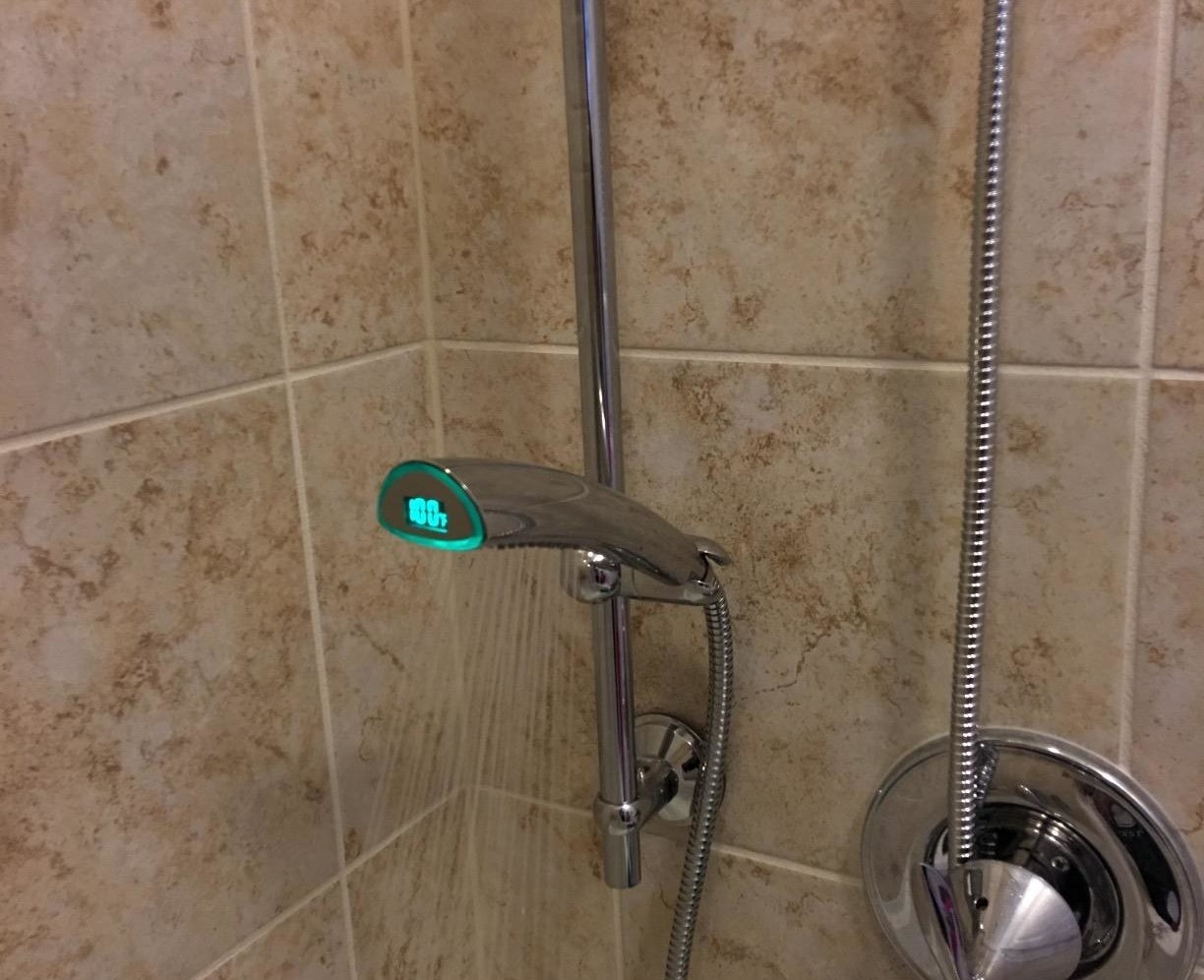 The shower head in use with the temperature displayed
