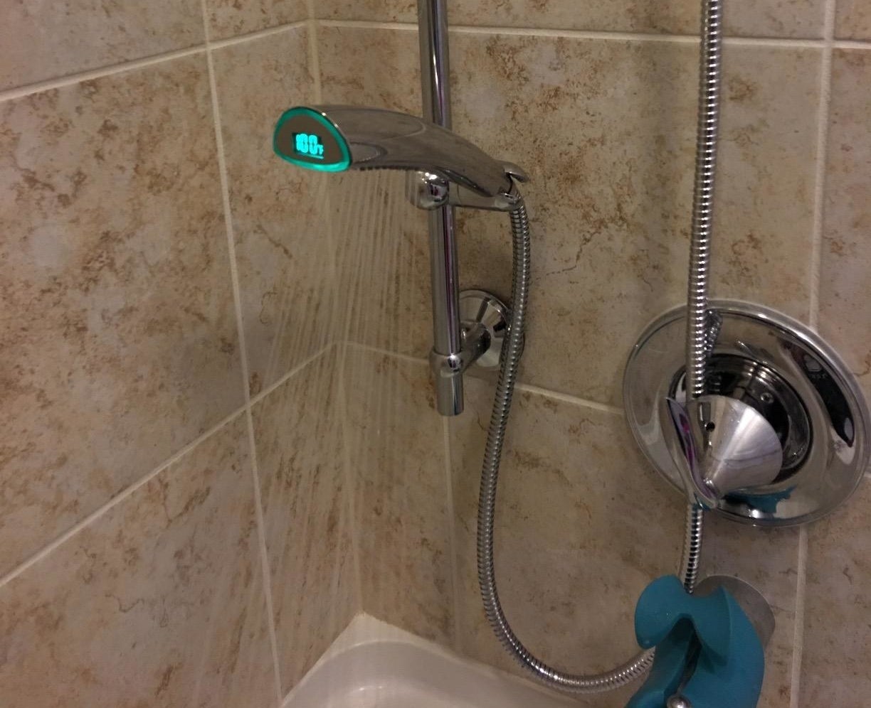 The shower head in use with the temperature displayed