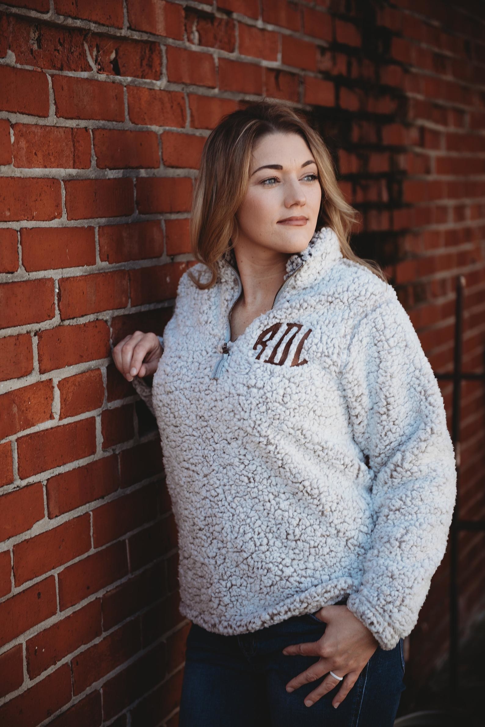 A model in the cream quarter-zip with monogram