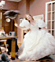 A person twirling around in a wedding dress and holding a duster