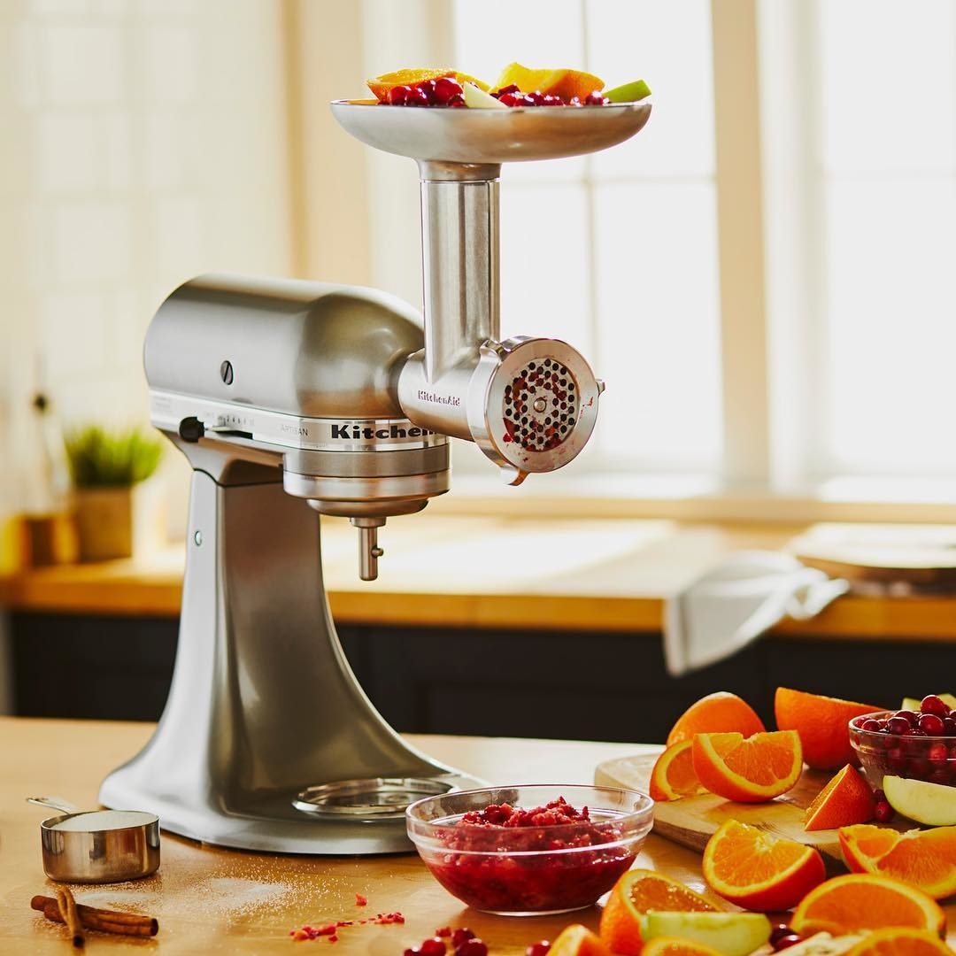 A KitchenAid mixer with a juicer attached to its head