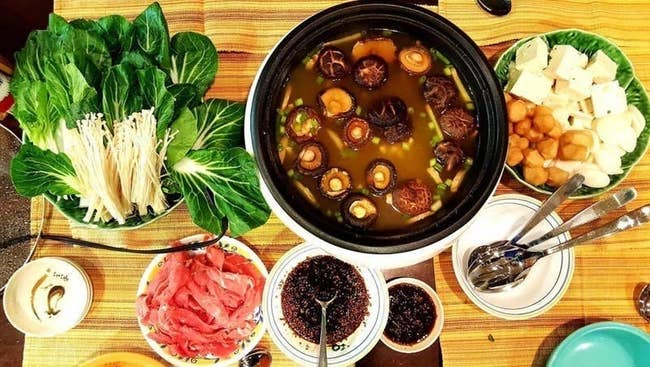 reviewer photo of the hot pot in black filled with food in and around it