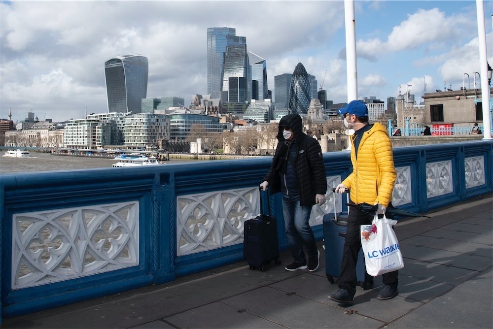 Tourists wear surgical masks on Tower Bridge on March 12.