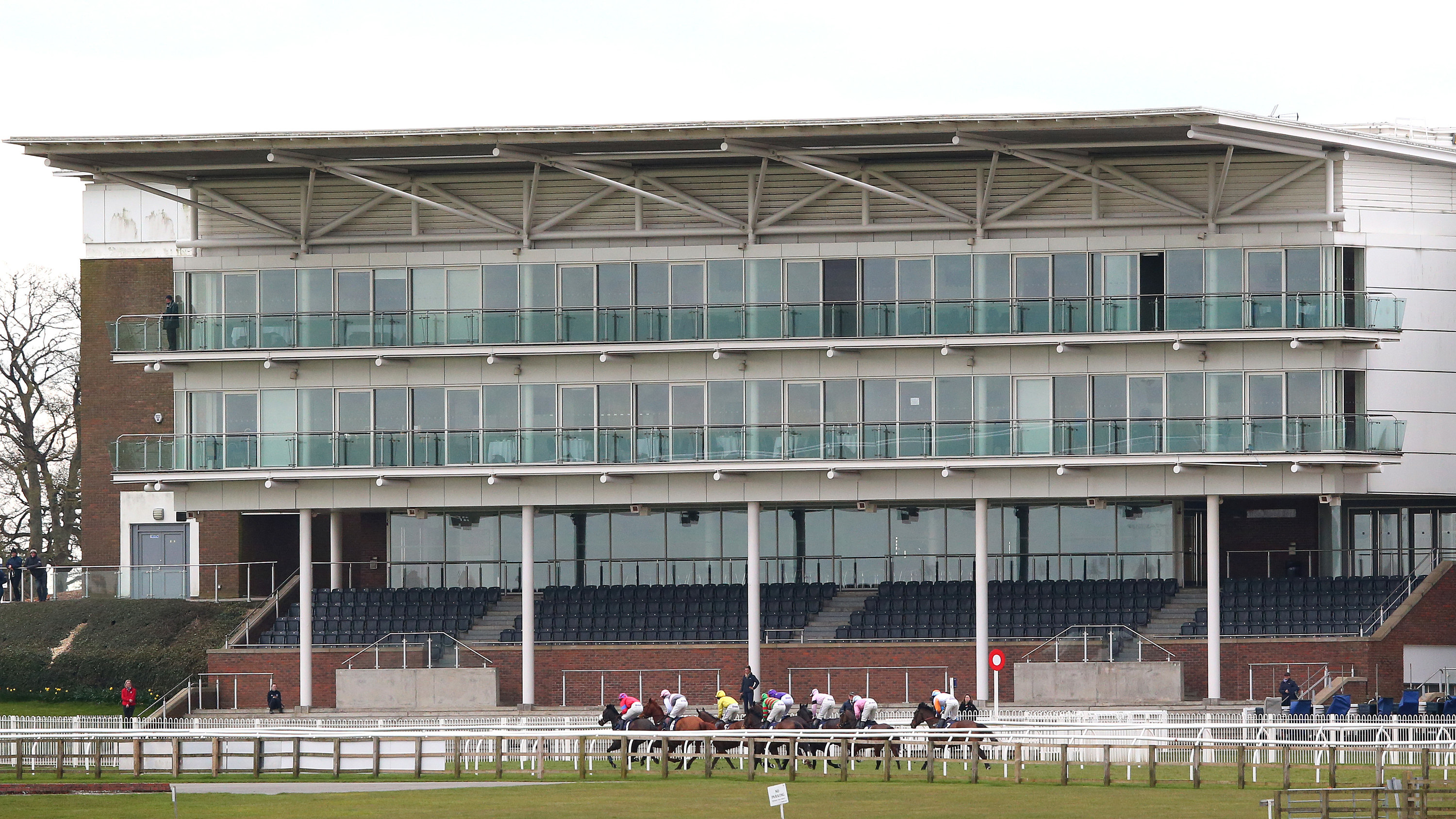 Empty stands are seen as horses and riders run past during a race