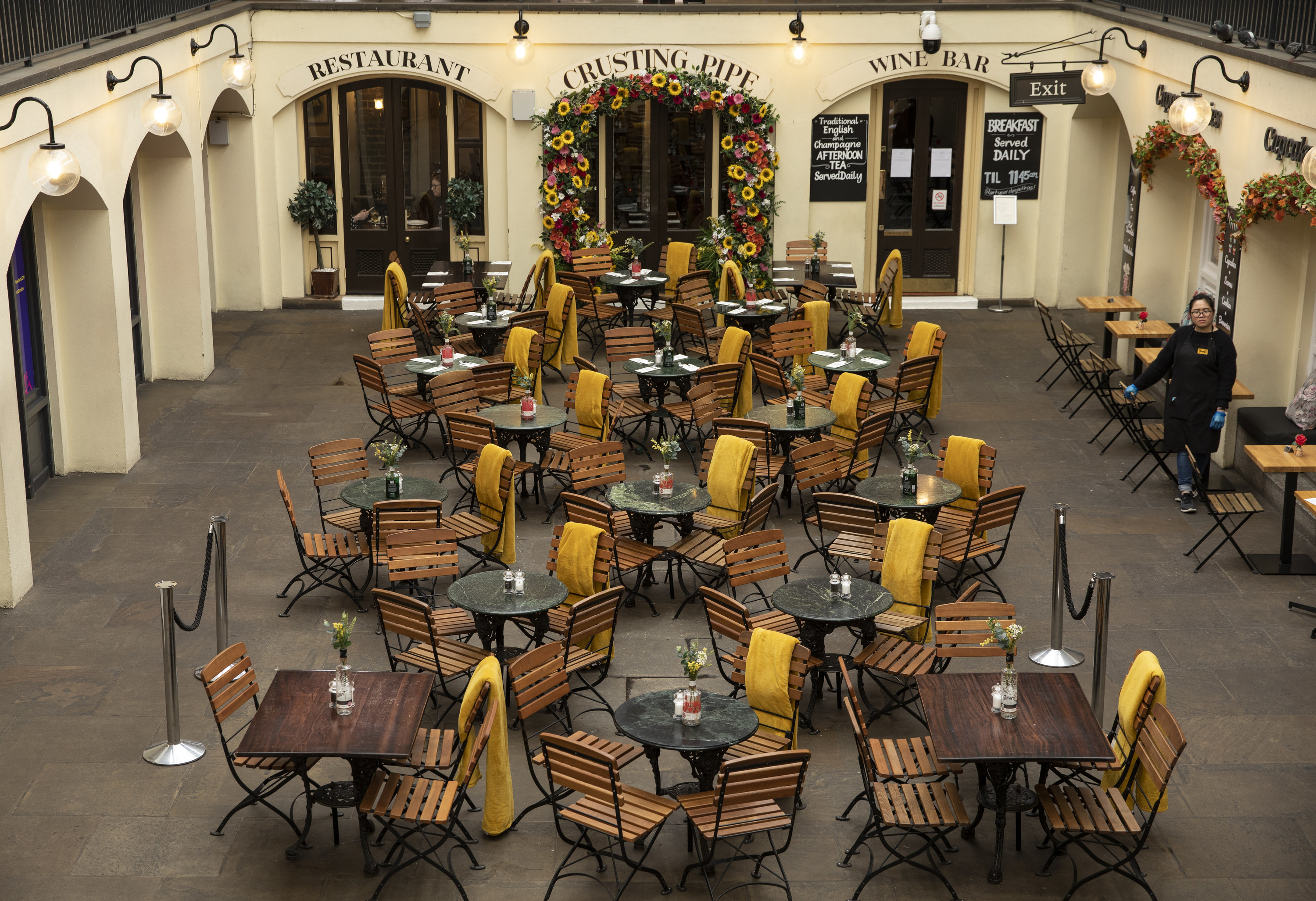 An employee waits over empty tables in Covent Garden on March 17, 2020 