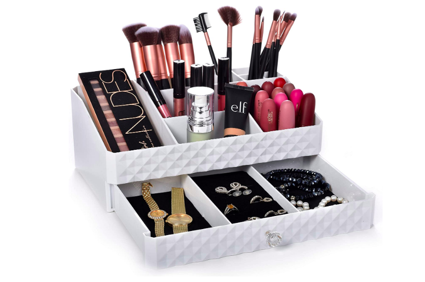 Cosmetic storage box filled with makeup brushes on top and jewelry on the bottom