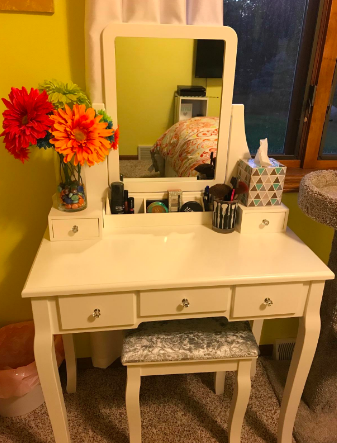 Reviewer's white vanity set with a bouquet of flowers and makeup compartments
