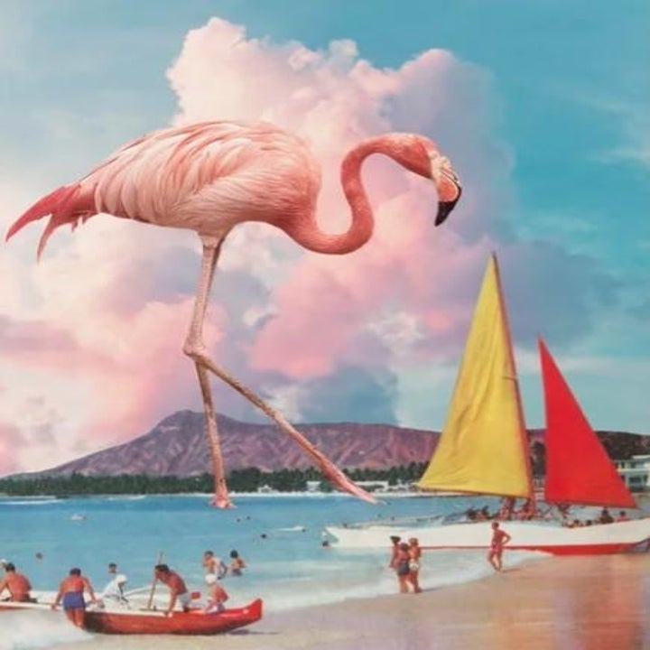 Giant flamingo standing above beach goers in the ocean 