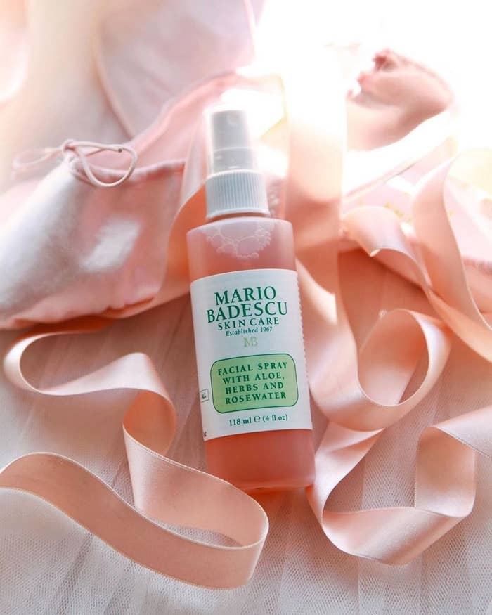 A bottle of the facial spray rests on some tulle and ribbon