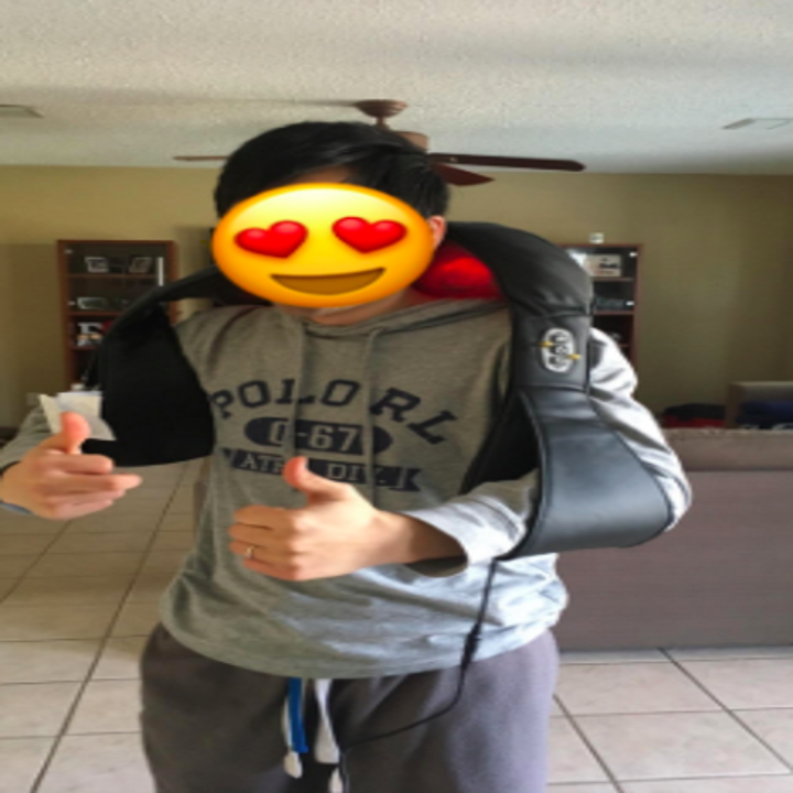 reviewer pic of person wearing the massager over a T-shirt, giving two thumbs up