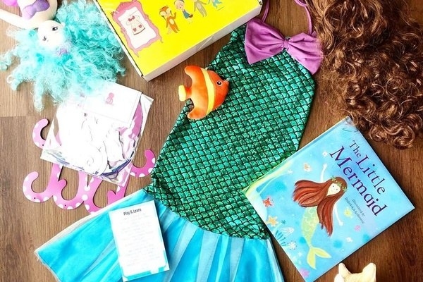 A mermaid children&#x27;s book and costume laid out with other themed items
