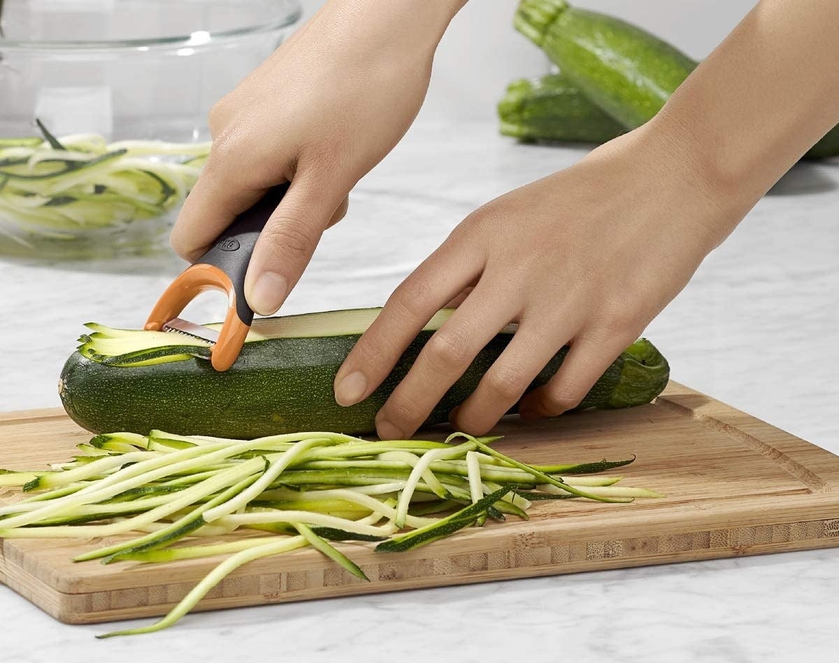 Model using julienne peeler to slice zucchini