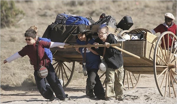 the kids pulling wagons of supplies