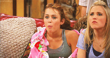 a gif of miley cyrus as hannah montana with popcorn falling out of her mouth