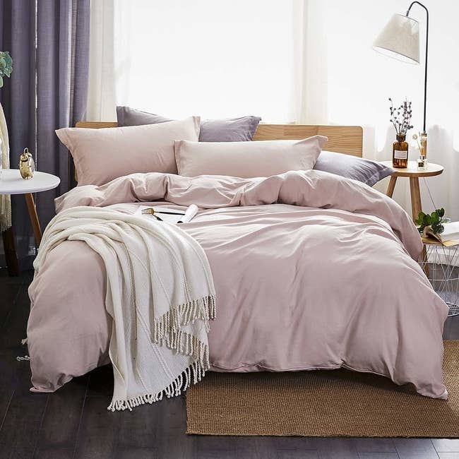 A pale purple duvet cover and pillows on a bed 