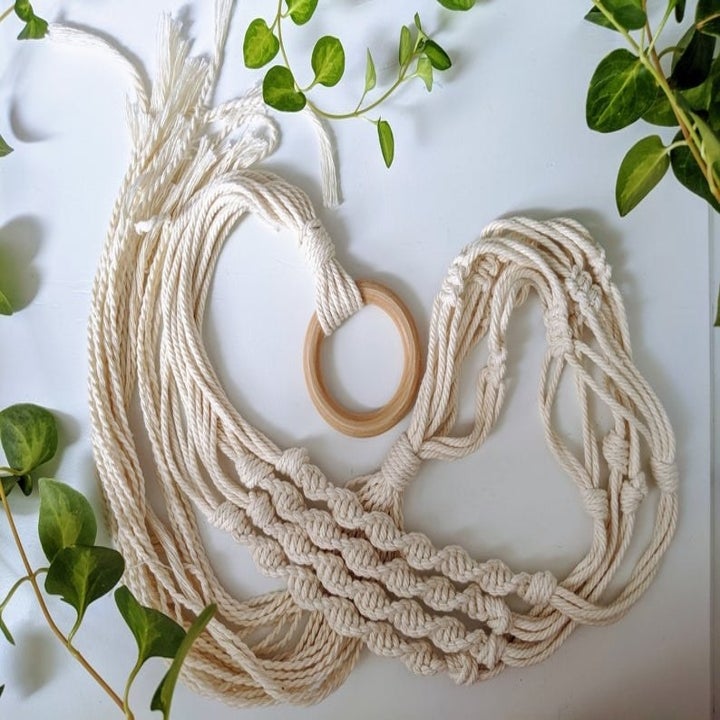 The macrame braided and tied to a hanging loop made of wood