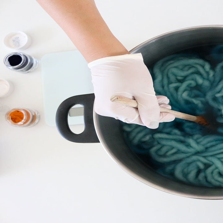 The same person dying wool in a pot