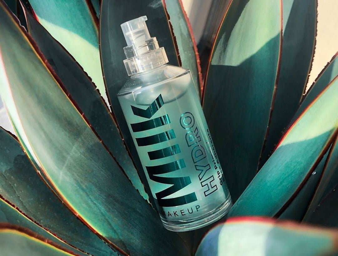 A bottle of primer nestled in a blue agave plant