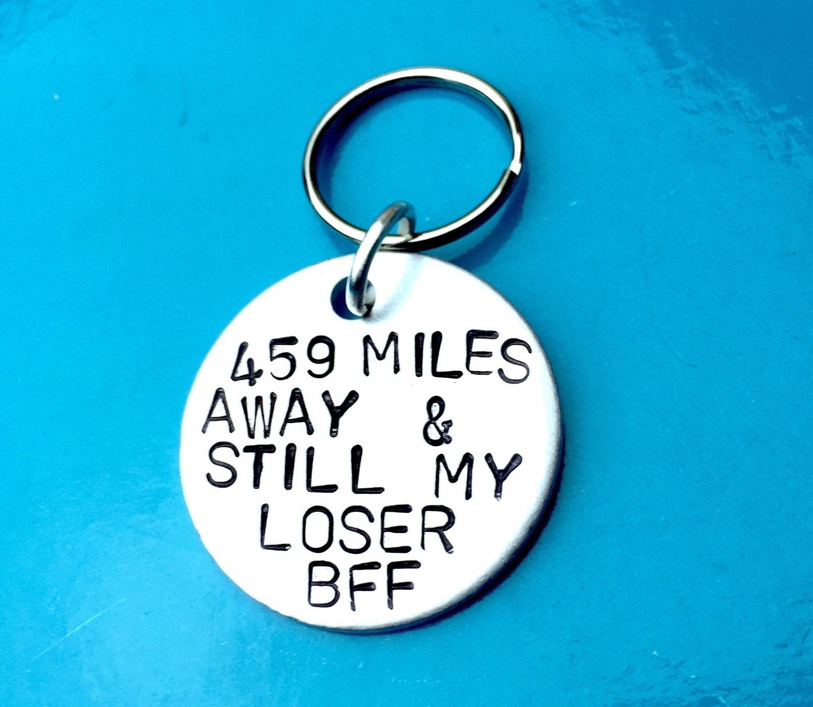 metal keychain that says &quot;459 mils away and stlll my loser BfF&quot; 