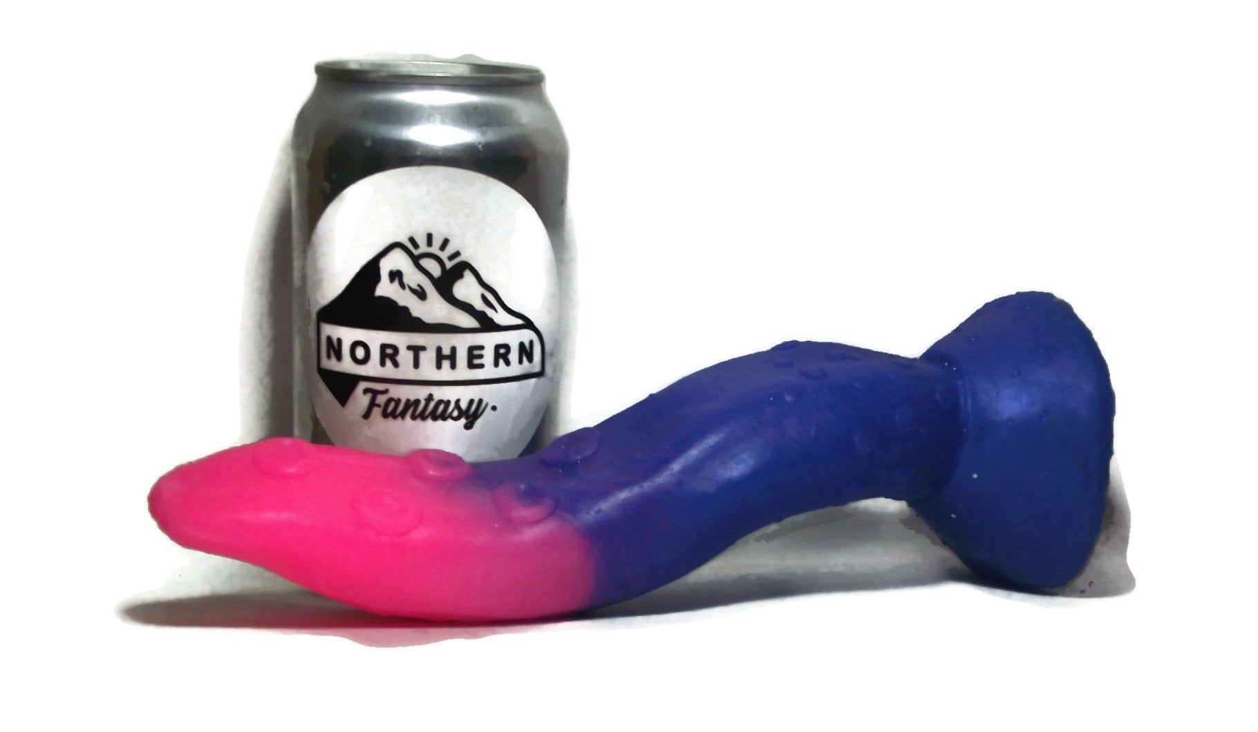 the blue and pink textured tongue toy next to a soda can 