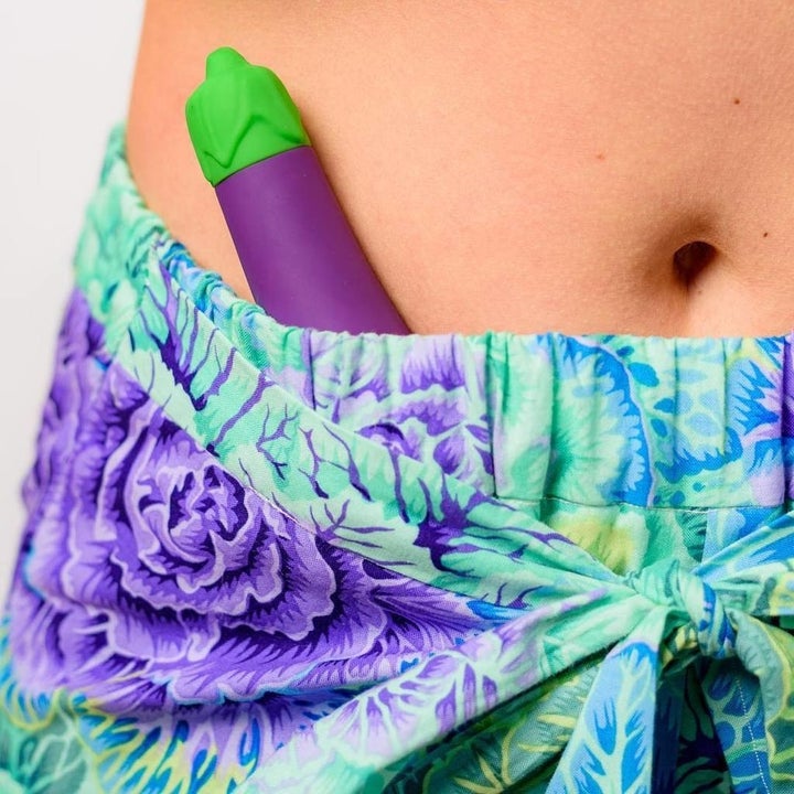 a model with the small eggplant-shaped vibrator tucked into their waistband