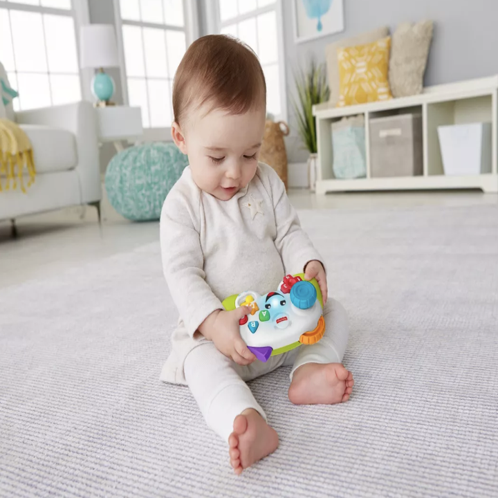 a baby holding a video game controller toy