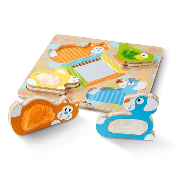 the wooden puzzle which features a mirror in the center and cut outs of various animals