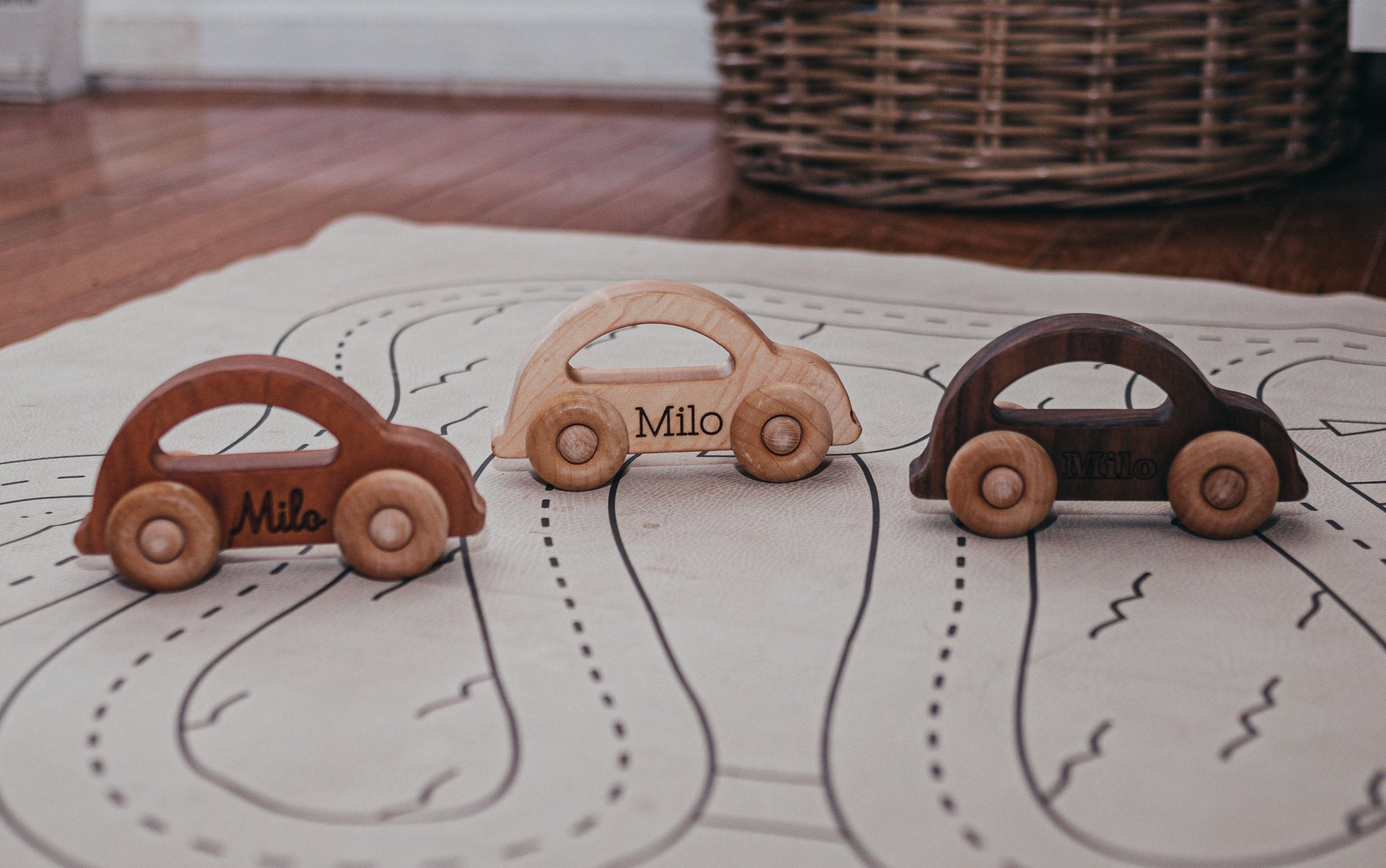 three cars in different colored woods with the name &quot;milo&quot; written on each one